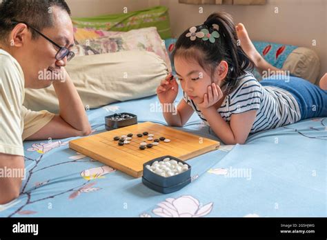 Asian cute child girl playing Go or Chinese traditional board game on ...