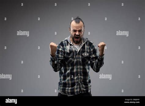 Bearded Man In Checked Shirt Aggressively Showing His Success With