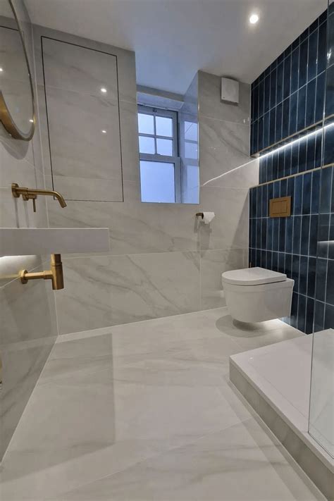 A Bathroom With Blue And White Tiles On The Walls