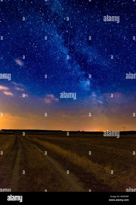 Milky Way Over Stubble Field And Rural Sandy Road Night Landscape With