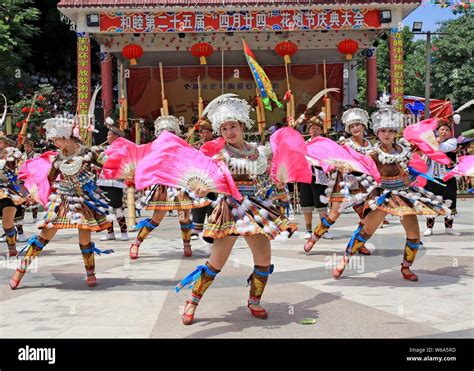 Chinese people of Miao ethnic group dressed in traditional costumes perform during the ...