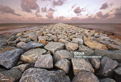 Ocean Jetty Made From Large Boulder And Moving Clouds Background Stock