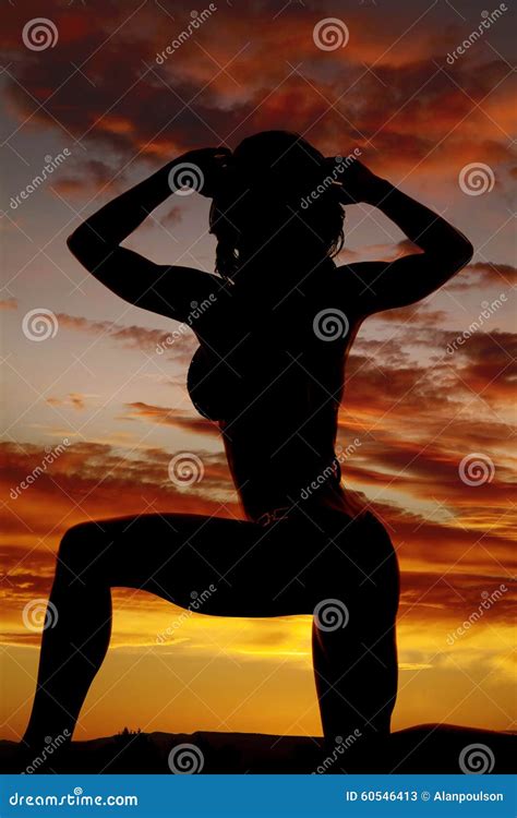 Silhouette Of A Woman In A Bikini On One Knee Hands In Hair Stock Image