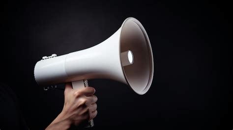 Uma Pessoa Segurando Um Megafone Contra Um Fundo Preto Foto Premium