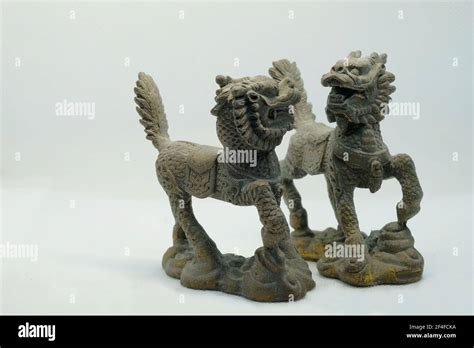 A pair of mythical Chinese bronze Qilin figurines, with head of a dragon, antlers of a deer ...