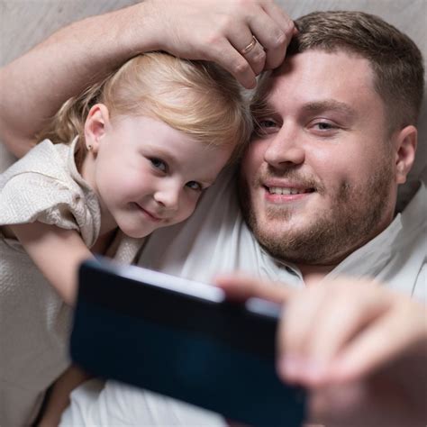 Padre E Hija Tomando Selfie En Casa Foto Gratis