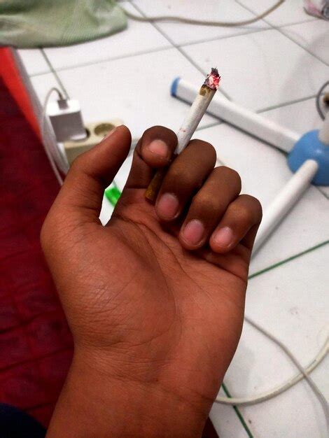 Premium Photo Close Up Of Hand Holding Cigarette