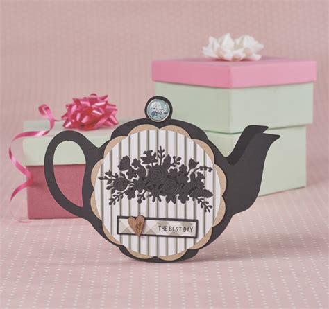 There Is A Teapot Shaped Card With Flowers On It Next To Two T Boxes