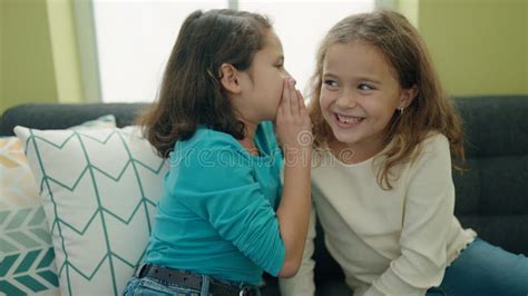 Two Kids Telling Secret Sitting On Sofa At Home Stock Photo Image Of