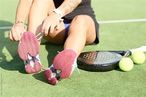 Padel Player Tying Sneakers By Stocksy Contributor Guille Faingold