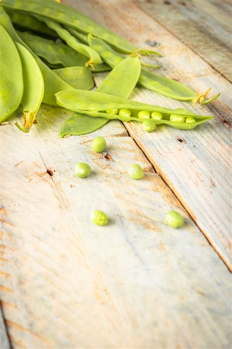 Fresh Green Peas Pods And Green Peas With Sprouts On Green Wooden