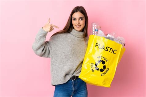 Joven mujer caucásica sosteniendo una bolsa llena de botellas de