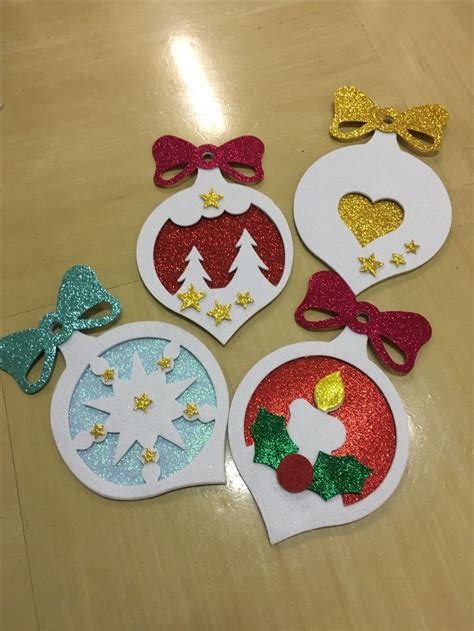 Four Christmas Ornaments On A Table With Bows And Glittered Decorations