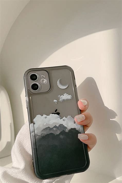 A Woman Holding Up Her Phone Case With An Image Of The Moon And Clouds On It