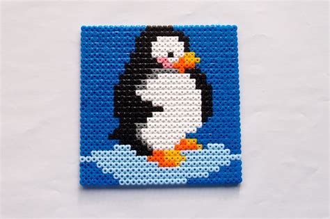 A Penguin Made Out Of Legos Sitting On Top Of A White Table Next To A