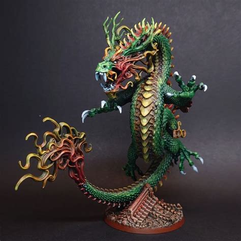 A Green And Red Dragon Statue Sitting On Top Of A Table