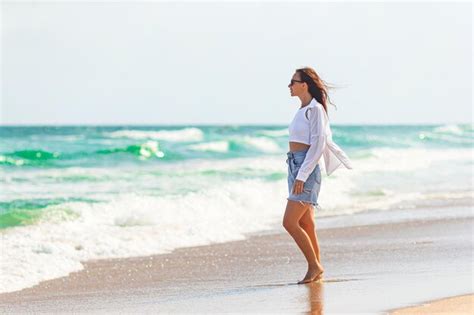 Premium Photo | Young beautiful woman on beach vacation walking by the sea