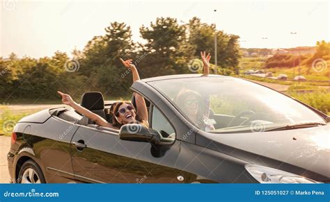 Dos Muchachas Hermosas Jovenes Que Conducen En Un Convertible Imagen De