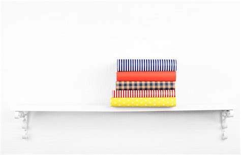 Premium Photo | Colorful covered books on bookshelf and white wall background