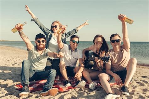 Grupo de amigos divirtiéndose en la playa Foto Premium