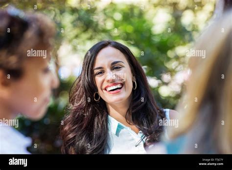 Woman laughing while standing by friends Stock Photo - Alamy