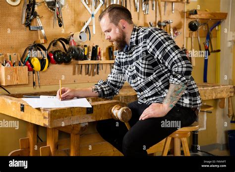 Carpenter planning new work in the workshop Stock Photo - Alamy