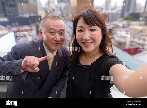 Portrait Of Mature Japanese Businessman And Mature Japanese Woman Exploring The City Of Bangkok