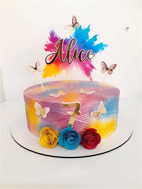 A Colorful Cake With Butterflies On Top And The Number One Candle In