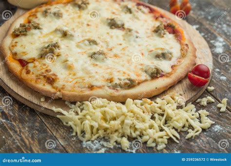 Whole Cheese Pizza on a Wooden Plate with Cheese Slices and Tomatoes on ...