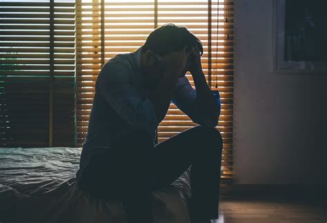 Depressed Man Sitting Head In Hands On The Bed In By Design Holistic