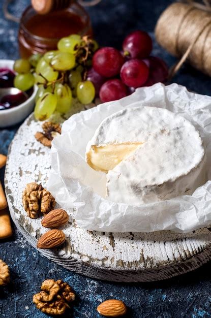 Premium Photo Camembert Cheese Brie Grapes Nuts And Crackers