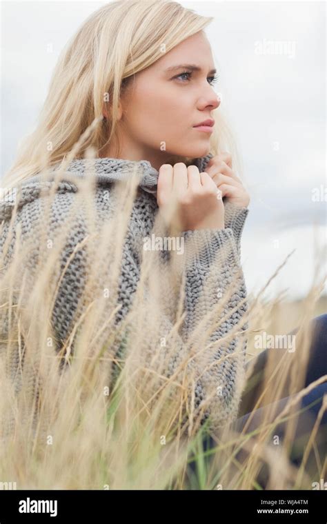 Close Up Side View Of A Cute Thoughtful Young Woman Lying On Grass At