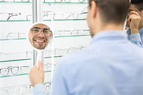 Tipo Feliz Eligiendo Gafas En La Tienda De ópticas Imagen de archivo