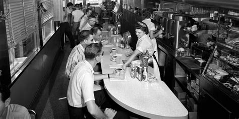 black and white photograph of diners at tables in a fast food ...