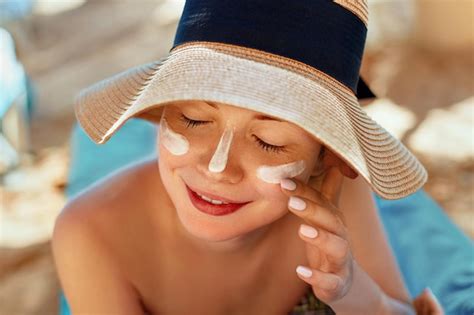 Premium Photo Facial Care Female Applying Sun Cream And Smiling