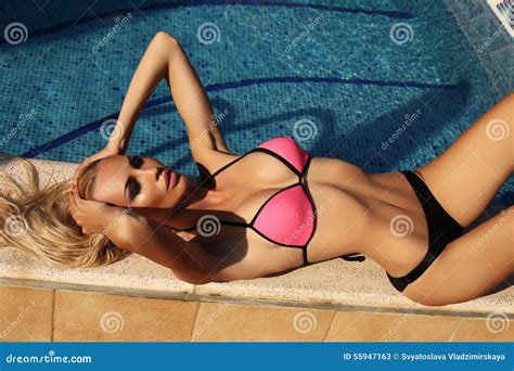 Blond Woman In Bikini Relaxing Beside A Swiming Pool Stock Image