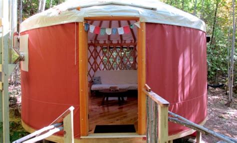 A Red And White Yurt In The Woods With Stairs Leading Up To It S Entrance