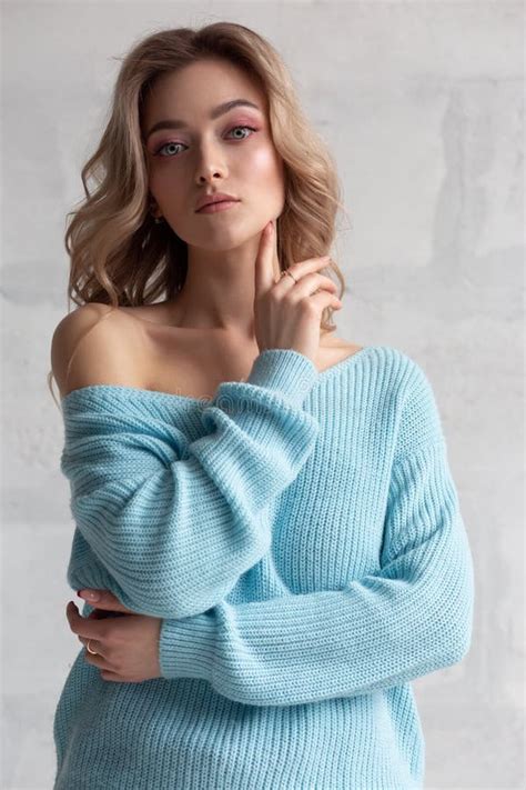 Blonde Girl In A Blue Knitted Sweater On A White Wall Background Stock Photo Image Of Black