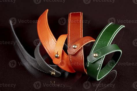 A Group Of Multi Colored Leather Belts On A Black Background 20000948