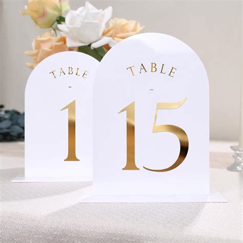 UNIQOOO Números de mesa de boda de arco blanco con soportes del 1 al 15