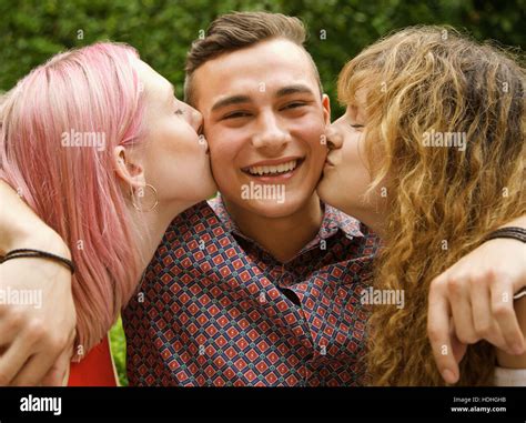 Side View Of Women Kissing Man On Cheeks At Yard Stock Photo Alamy