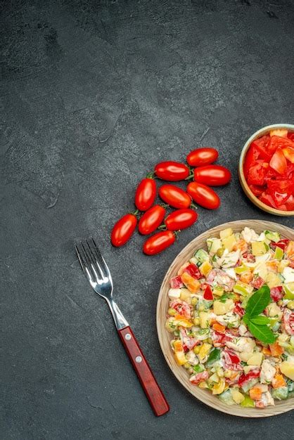 Vista Superior Da Salada De Legumes Tomate E Garfo Em Fundo Cinza