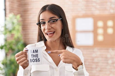 Young Brunette Woman Drinking From I Am The Boss Coffee Cup Smiling