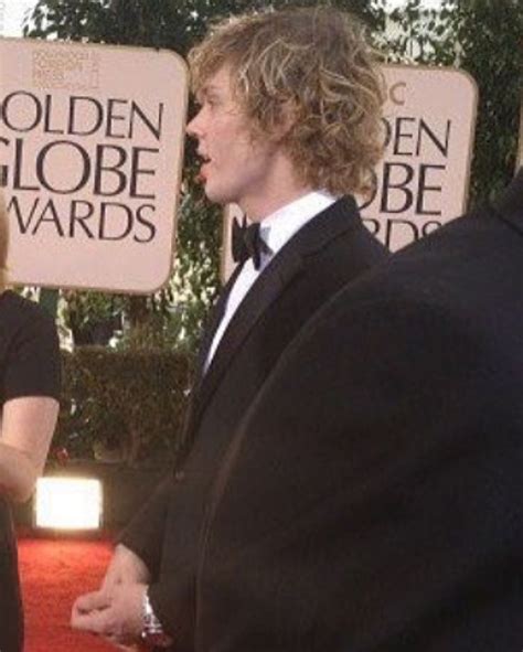 Two People In Tuxedos Talking To Each Other On The Red Carpet At An Event