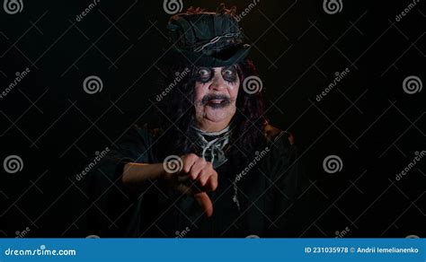 Sinister Senior Old Woman In Costume Of Halloween Witch Showing Thumbs