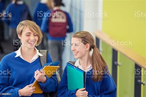 Dua Siswa Perempuan Tersenyum Mengenakan Seragam Sekolah Berjalan