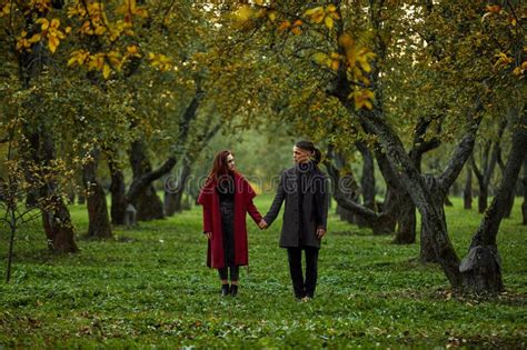 Young Couple In Love Walking In The Autumn Park Holding Hands Looking