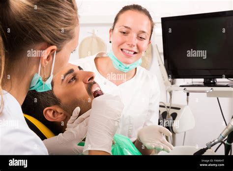 Female Dentist Examines The Oral Cavity On Computer Equipment Focus On