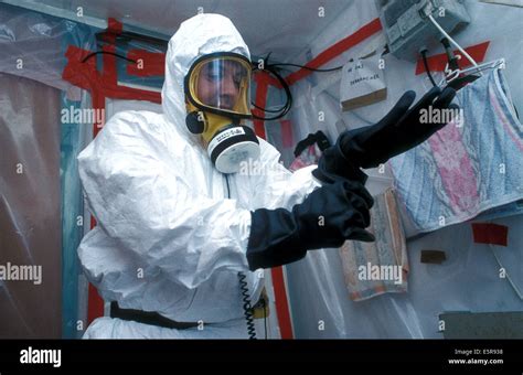 Worker Putting On A Protection Suit Before Working On Asbestos Removal