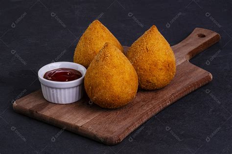 tradicional coxinha frita em tábua de madeira sobre pedra ardósia